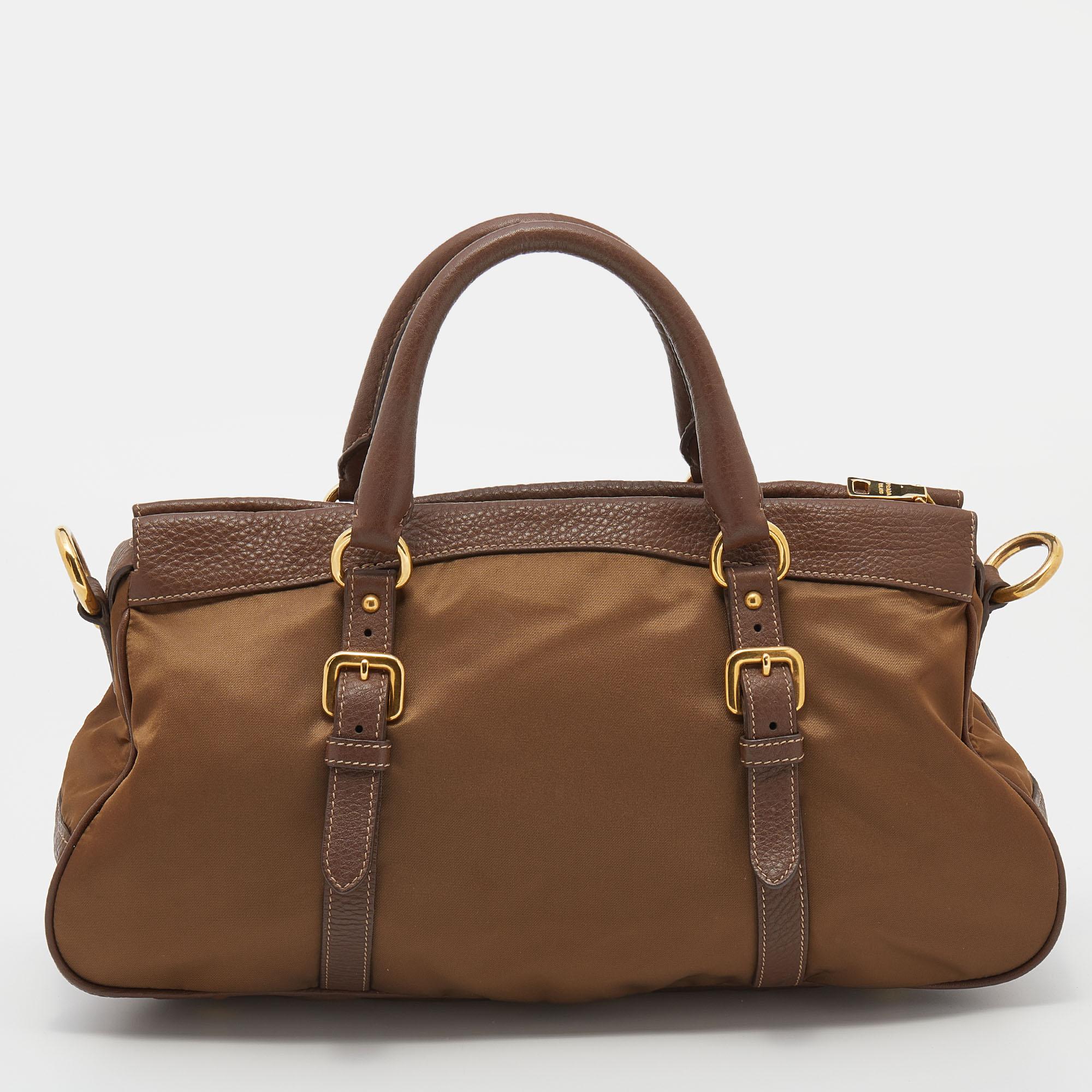 Filled with functional elements, this satchel from Prada is great for everyday use. It is made from brown leather and nylon and features a double buckle design on both sides, a spaciously sized interior, and gold-tone hardware. With a shoulder strap