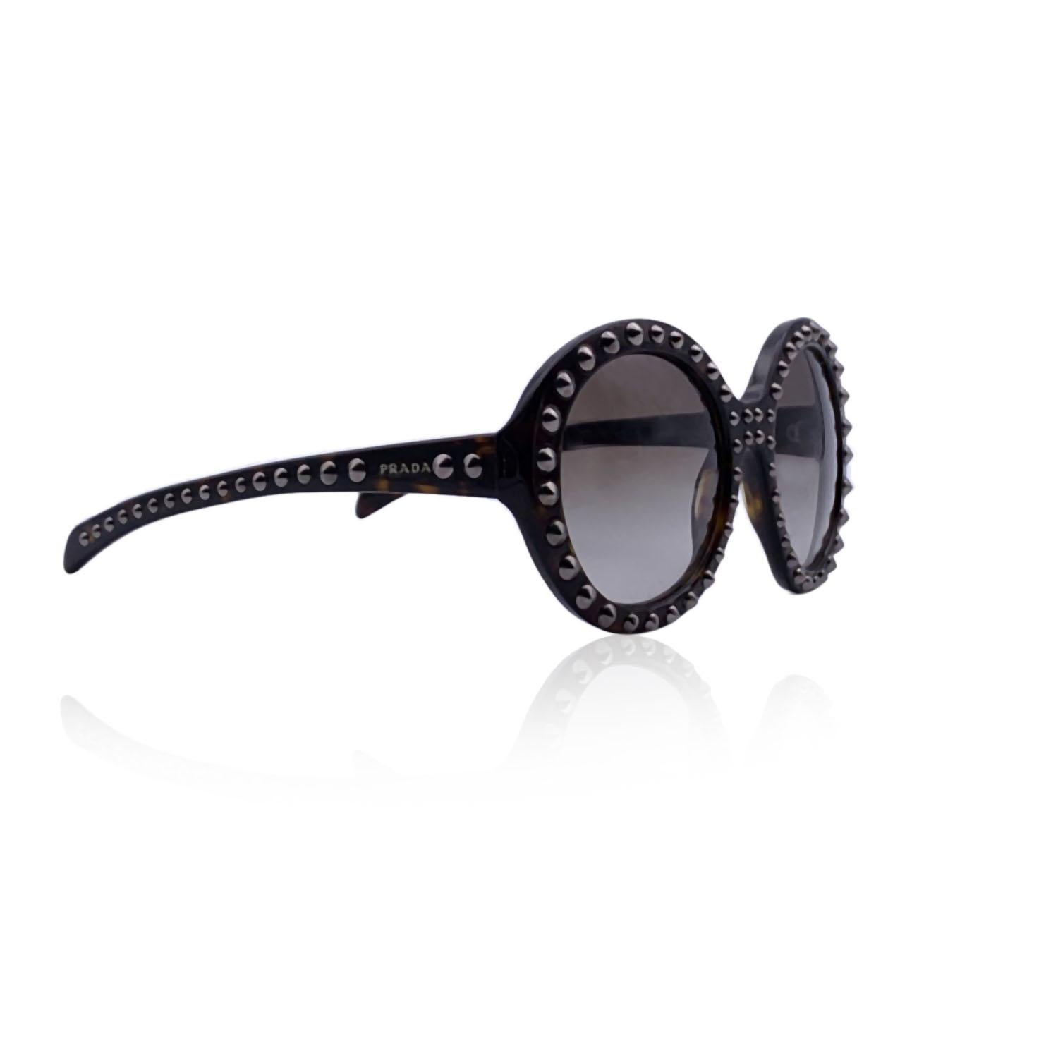 Stunning sunglasses by Prada, mod. SPR 29Q col.2AU-0A7. Round oversized shape in dark brown acetate embellished with silver metal studs. Logo on the temples and gradient gray lenses. Mod & refs.: mod. SPR 29Q - ol.2AU-0A7 - 56/21 - 140. Made in