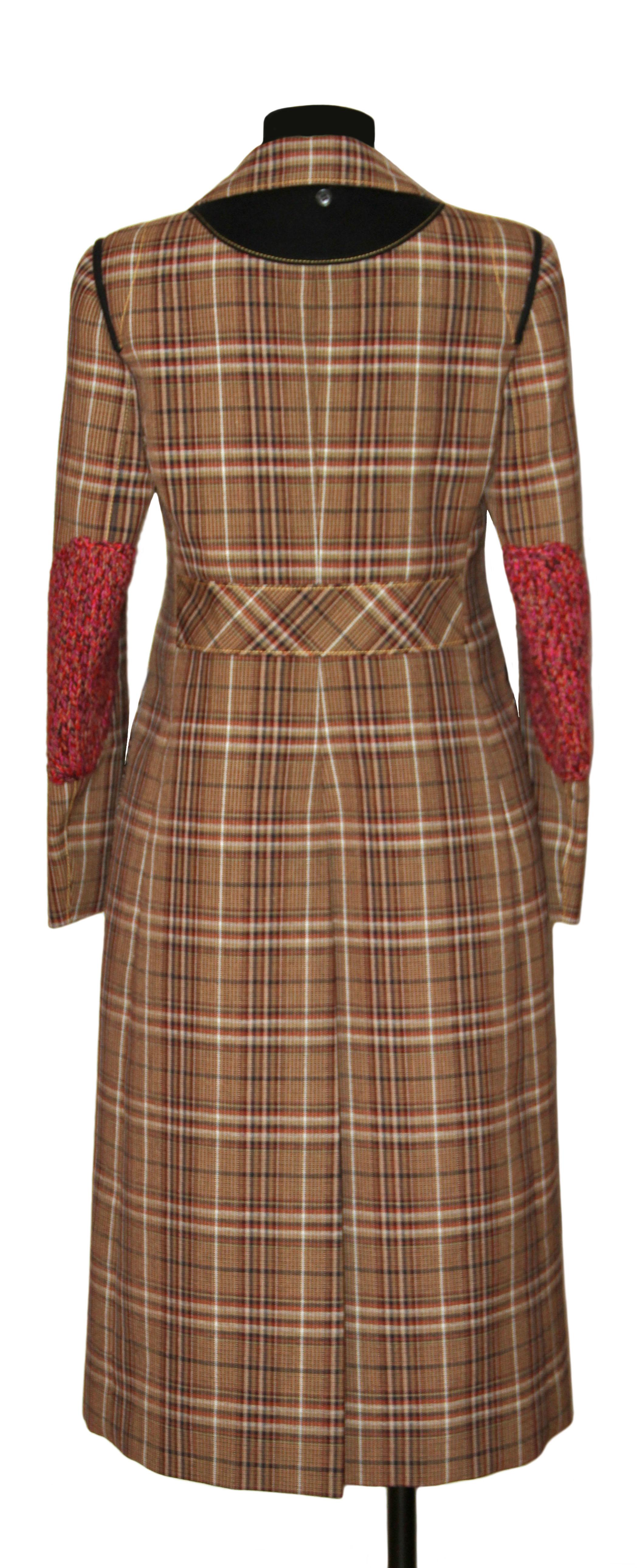 Beautiful coat from the house of Prada. Its classic Prince of Wales checked-weave fabric and its contemporary cut with specific details as slender waist, A-line cut from the waist as well as knit elbows and detachable shearling hood, make this coat