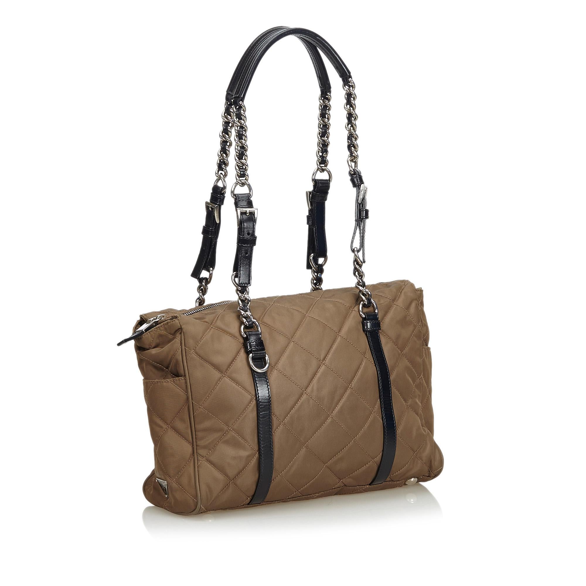 This shoulder bag features a quilted nylon body, exterior side slip pockets, silver-tone shoulder chain, a top zip closure, and interior zip pocket. It carries as AB condition rating.

Inclusions: 
Authenticity Card

Dimensions:
Length: 25.00