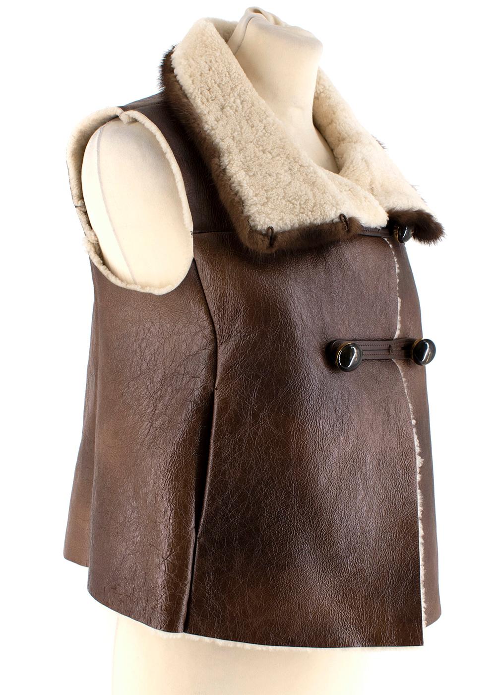 Prada Brown Shearling Lined Sheepskin Leather Gilet with Mink Fur Trim

- Button Toggle Fastening
- Fabric Clasp on Mink Fur Collar
- Two Outside Pockets 
- Comes with Spare Button 

Materials
- 100% Dyed Sheep Fur (Spain) 
- 100% Natural Mink Fur