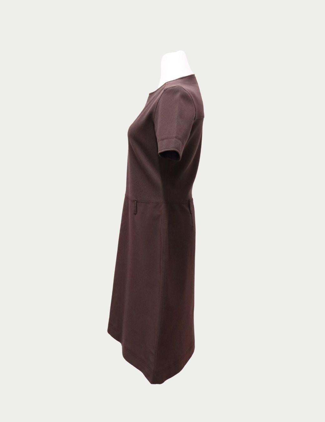 Prada Braunes Kleid mit kurzen Ärmeln und A-Linie - Minimalistisch geschnittener Crêpe

Dieses braune, kurzärmelige Kleid in A-Linie von Prada ist ein zeitloses Stück, das die raffinierte, minimalistische Ästhetik der Marke verkörpert.

Das aus