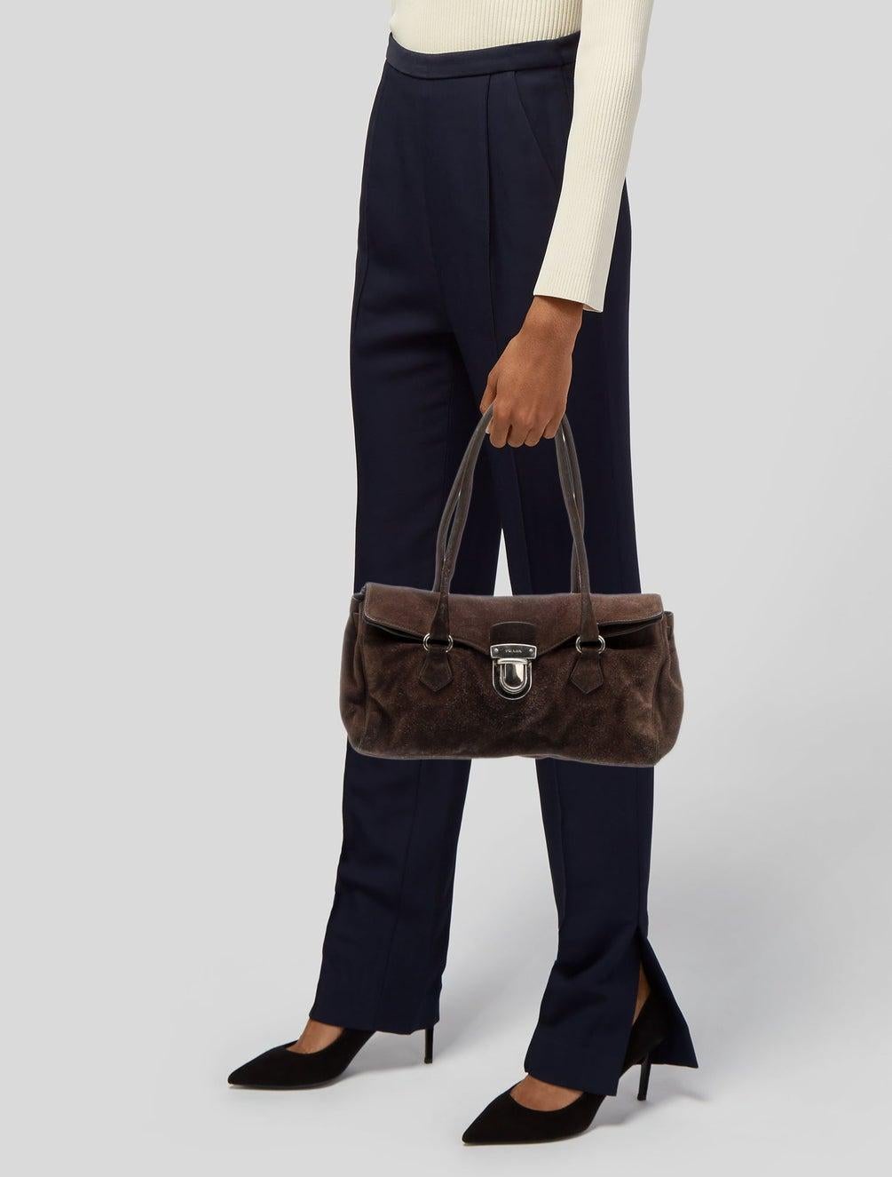 This bag is constructed of brown Scamosciato suede (Moro Camoscio) with silver-tone hardware. It features dual top handle straps and a front push-lock closure. The interior is lined with logo jacquard fabric and includes a single pocket.

Color: