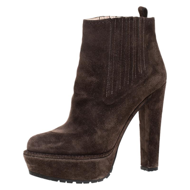 Show off your style as you flaunt these ankle boots from Prada. Crafted in Italy, they are made from quality suede and come in a lovely shade of brown. They are styled with round toes, platforms, 13.5 cm heels, gold-tone hardware and a sleek