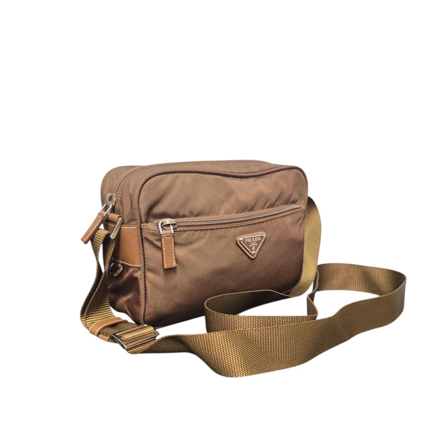 Découvrez le mélange parfait de luxe et de praticité avec ce sac transversal en nylon Prada Tessuto. En Elegant Brandy (brun doré), ce sac est fabriqué en nylon Tessuto résistant et agrémenté de garnitures en cuir, ce qui garantit sa durabilité et