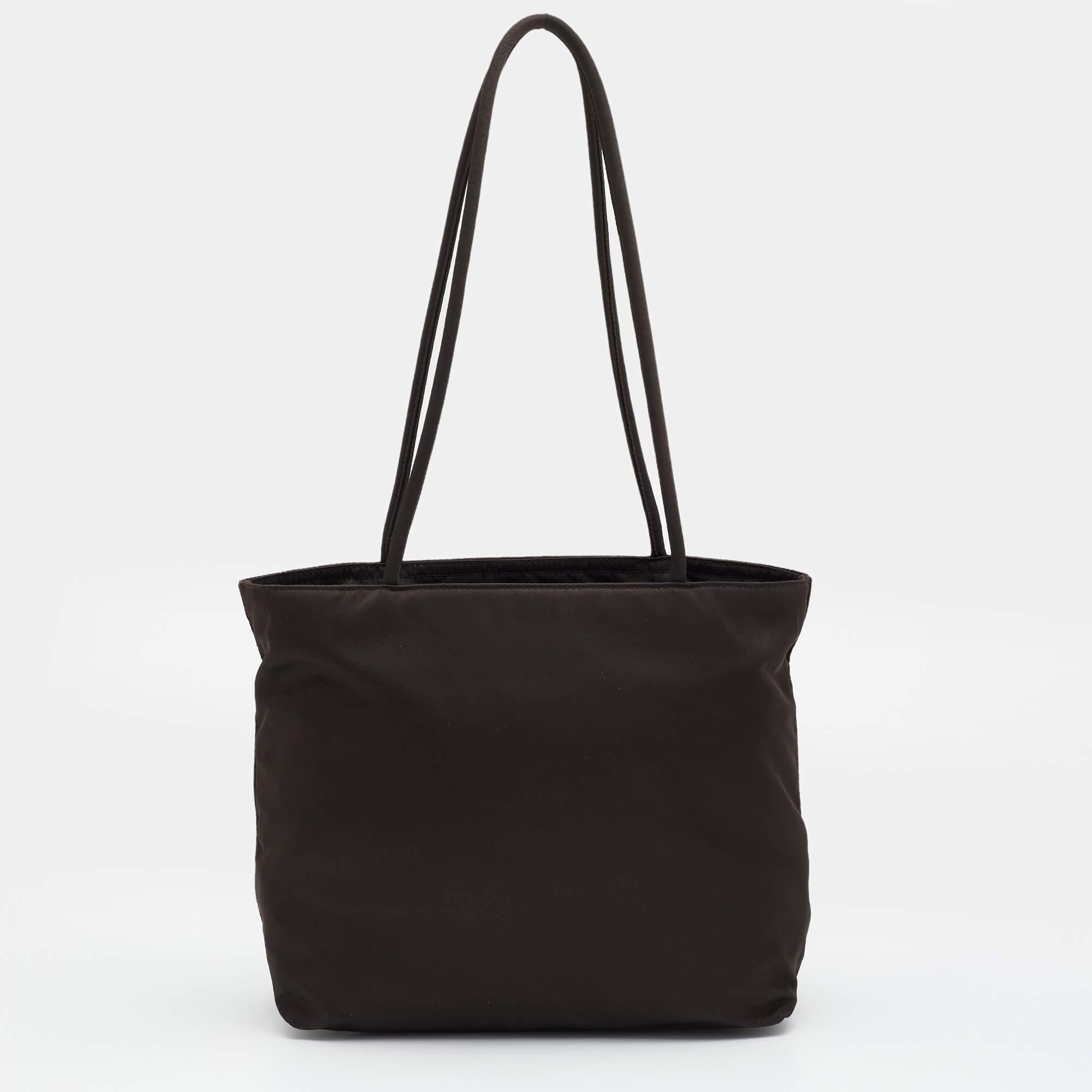 This Prada tote strikes the right balance between fashion and function. Crafted from nylon, it flaunts a brand signature on the front, dual handles at the top, and a perfectly sized interior.

