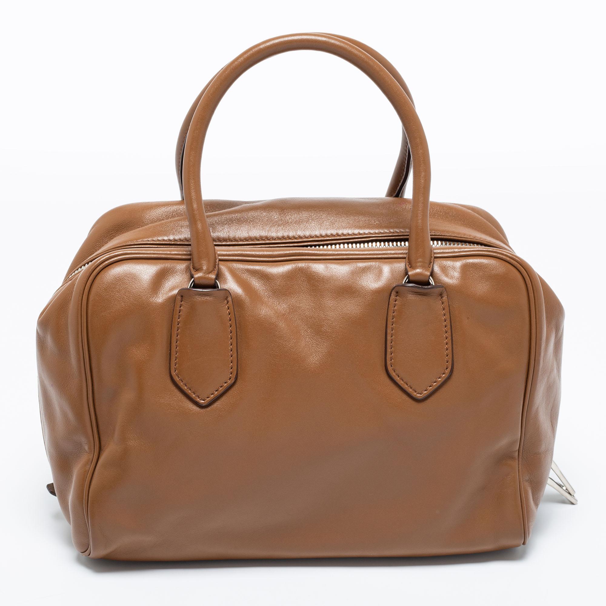 A perfect everyday bag to hold all that you need while being chic and of a practical size, this Prada bag is hard to miss. Crafted in brown-turquoise leather, this bag features a top zipper closure that opens to a capacious interior.

Includes: