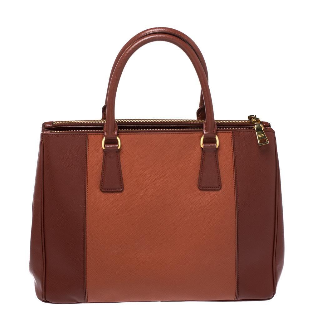 Feminine in shape and grand on design, this Double Zip tote by Prada will be a loved addition to your closet. It has been crafted from leather and styled minimally with gold-tone hardware. It comes with two top handles and a perfectly-sized main