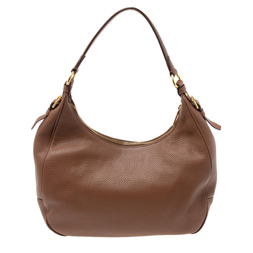 Crafted from Vitello Daino leather, this hobo from Prada is designed with minimal style details but with high attention to craftsmanship so that it may assist you with durability. The spacious interior of the bag is lined with nylon and the hobo is