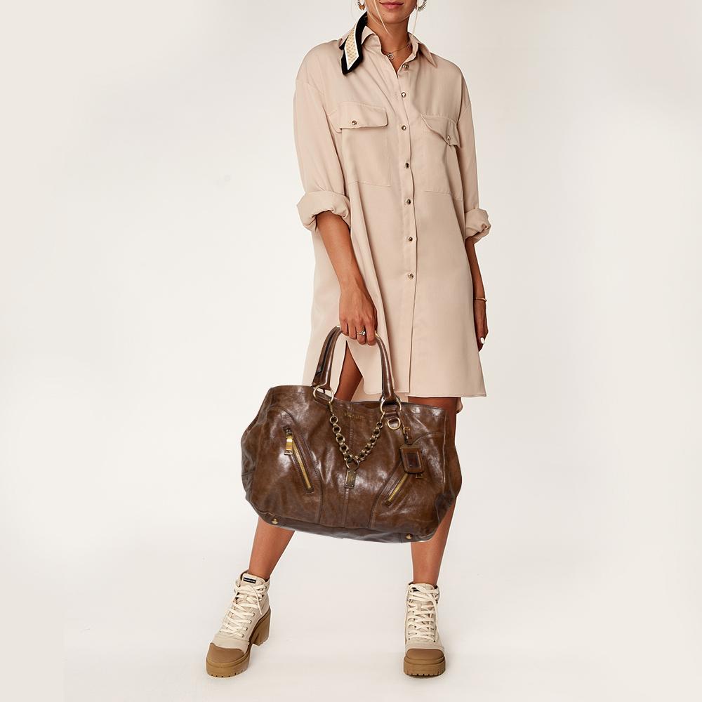 Diese wunderbare Prada-Kreation ist aus Leder gefertigt und mit goldfarbenen Beschlägen verziert. Die Tasche hat eine einfache Form:: einen geräumigen Innenraum und zwei Griffe. Die Ledertasche von Prada trägt Ihre täglichen Habseligkeiten mit
