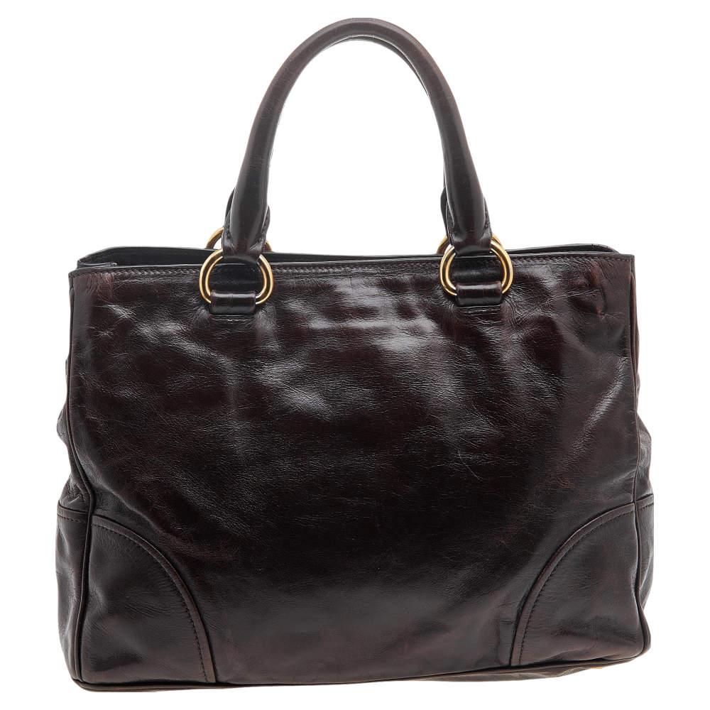 This Prada tote is finely crafted using Vitello Shine leather and fitted with dual top handles. It can be hand-held or placed on your arm. It has a spacious lined interior and the brand logo at the front.

