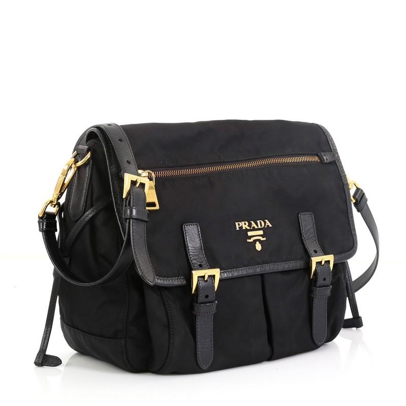 This Prada Buckle Messenger Bag Tessuto Small, crafted in black nylon and fabric, features an adjustable crossbody strap, full frontal flap and gold-tone hardware. Its push-lock closure opens to a black fabric interior with zip pocket. 

Estimated