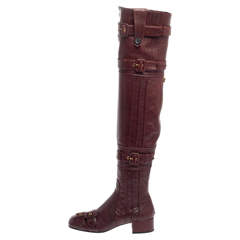 The multiple buckle straps enhance the appeal of these Prada boots. Covered in leather, the burgundy shoes have covered toes, gold-tone hardware, and block heels. The zipper closure at the back gives this over-the-knee pair a practical