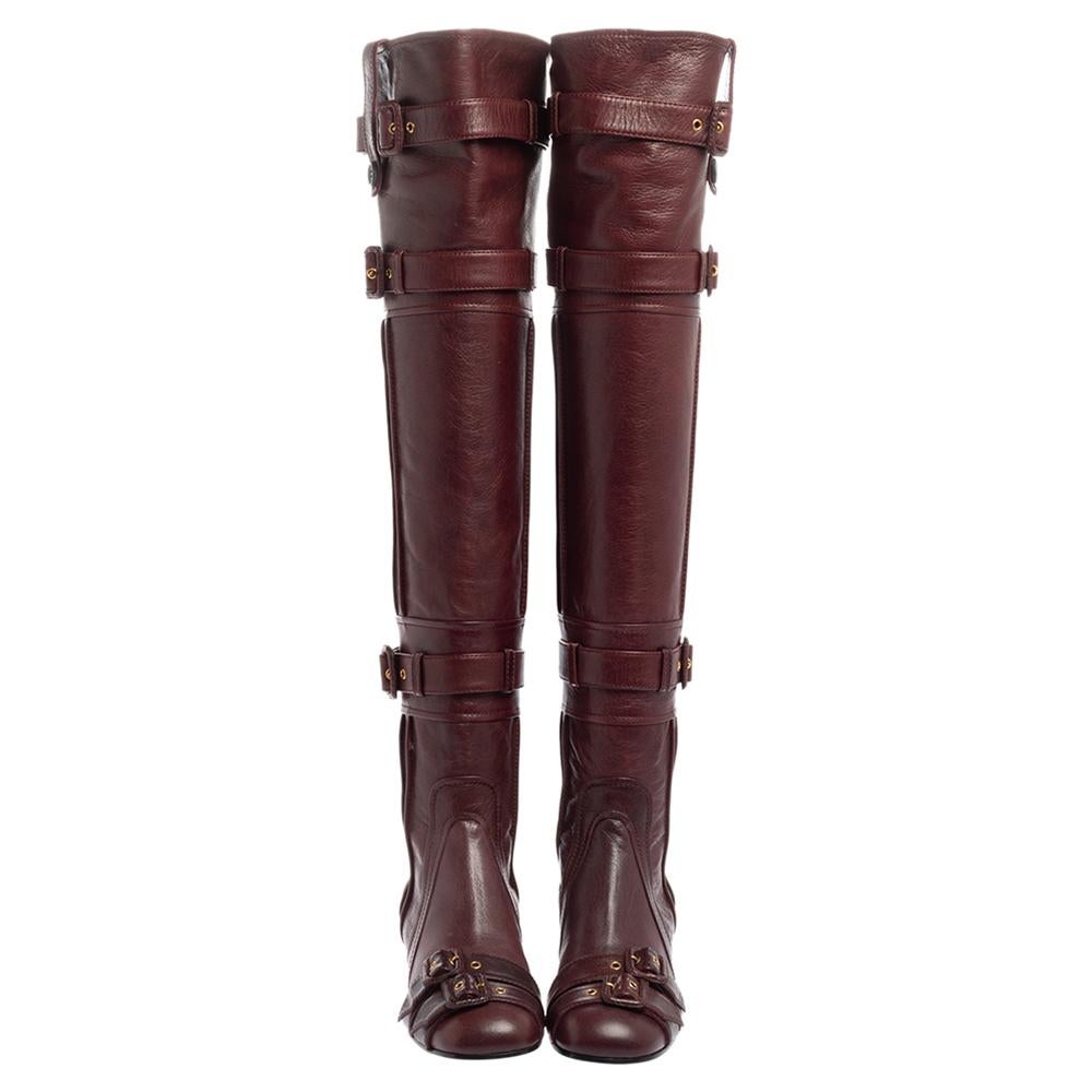 The multiple buckle straps enhance the appeal of these Prada boots. Covered in leather, the burgundy shoes have covered toes, gold-tone hardware, and block heels. The zipper closure at the back gives this over-the-knee pair a practical