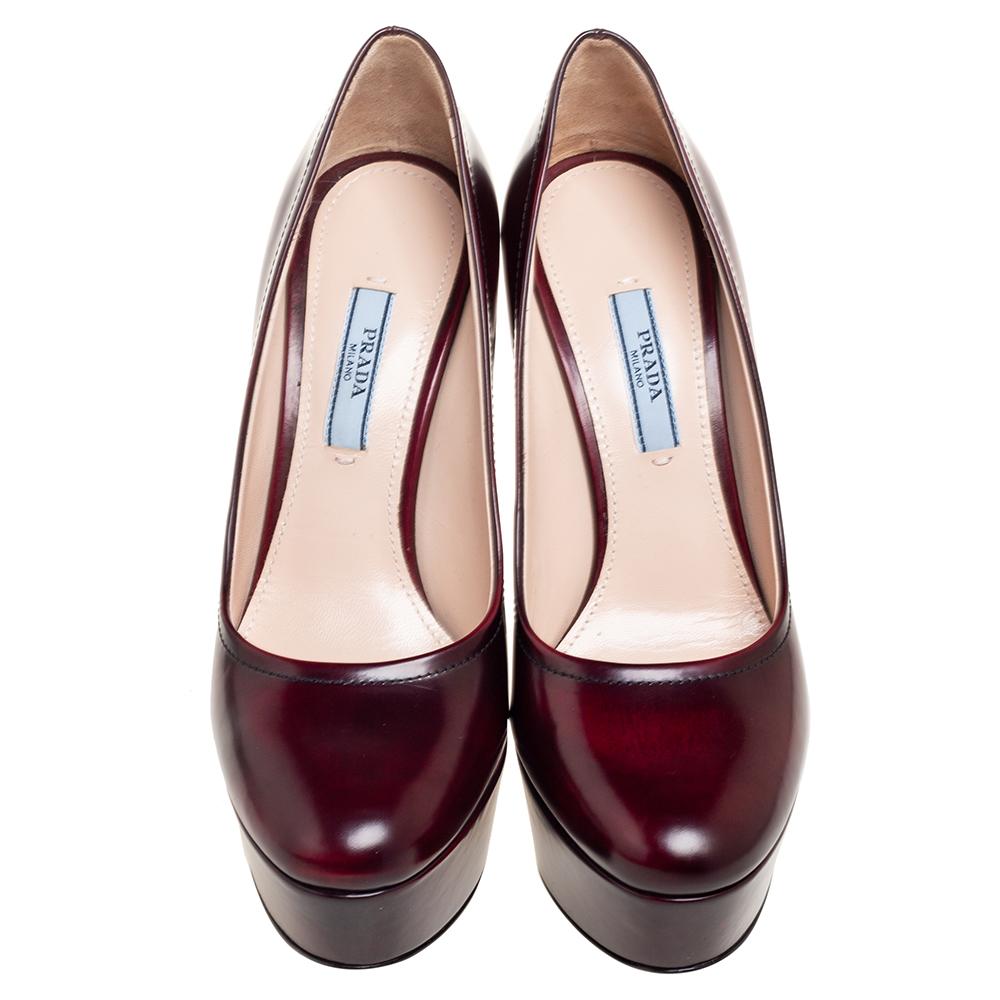 Make an impressive style statement by wearing these pumps from the House of Prada. They are crafted using burgundy leather and are adorned with rounded toes, platforms, and block heels. Simple yet stylish, these Prada pumps will amp up your trend