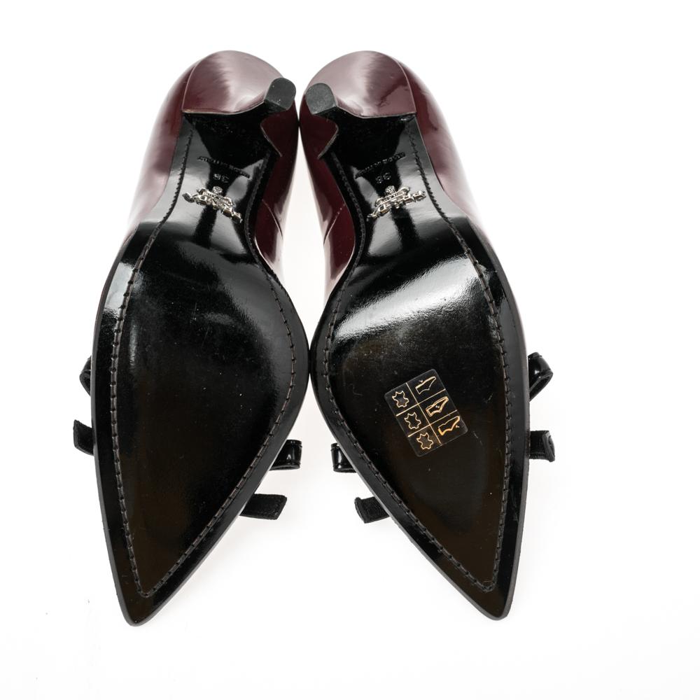 Effortlessly elegant and chic, are these Prada pumps. They are crafted from burgundy-colored patent leather, and they are adorned with black leather trim and bows on their vamps. They have pointed toe caps and 11 cm heels.

