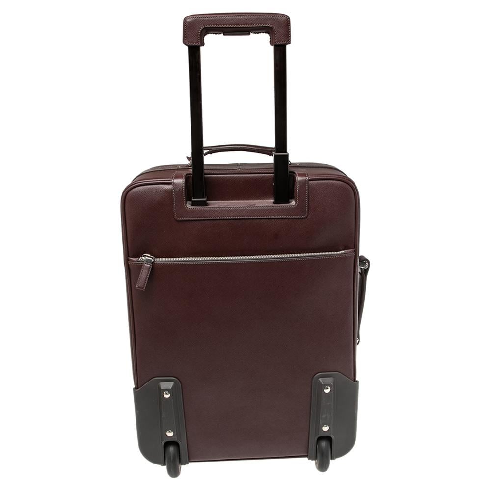 Say hello to your new traveling partner from Prada. The exterior has been crafted from Saffiano leather while the spacious interior is lined with nylon. Equipped with a zip pocket at the front, a flat handle, two wheels, and a telescopic cane, this