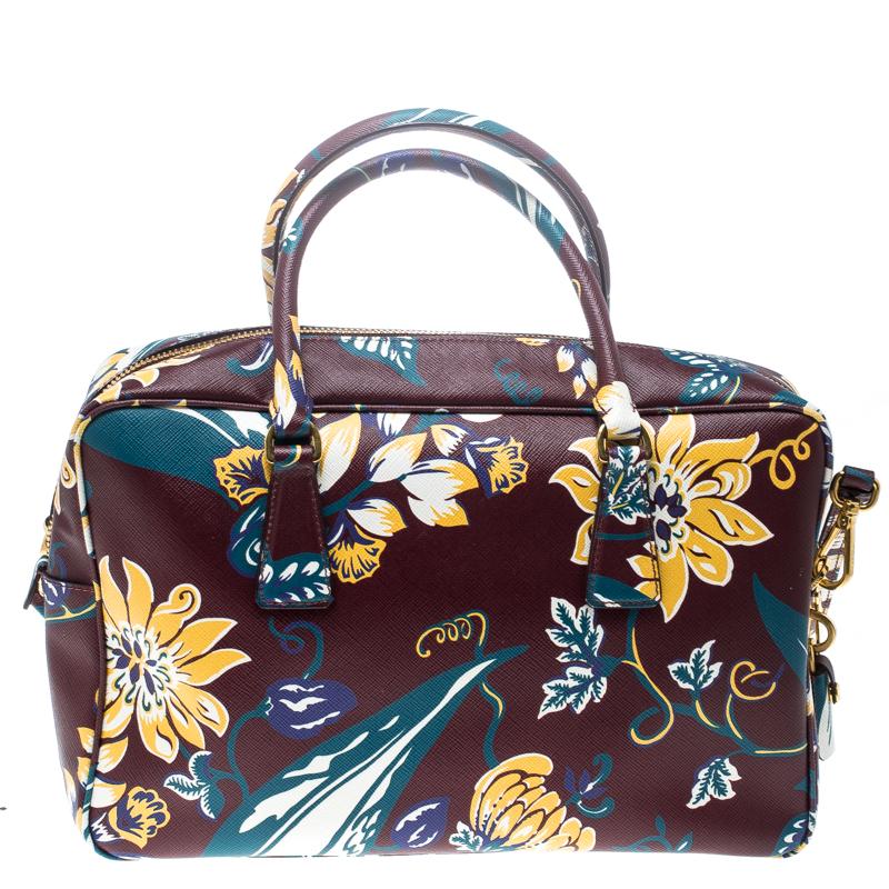 This elegant Bauletto bag from Prada is crafted from Saffiano leather and is perfect for your fashionable outings. The beautiful burgundy colour is ravishing. The bag features splendid details in the form of the multicolour floral print all over,