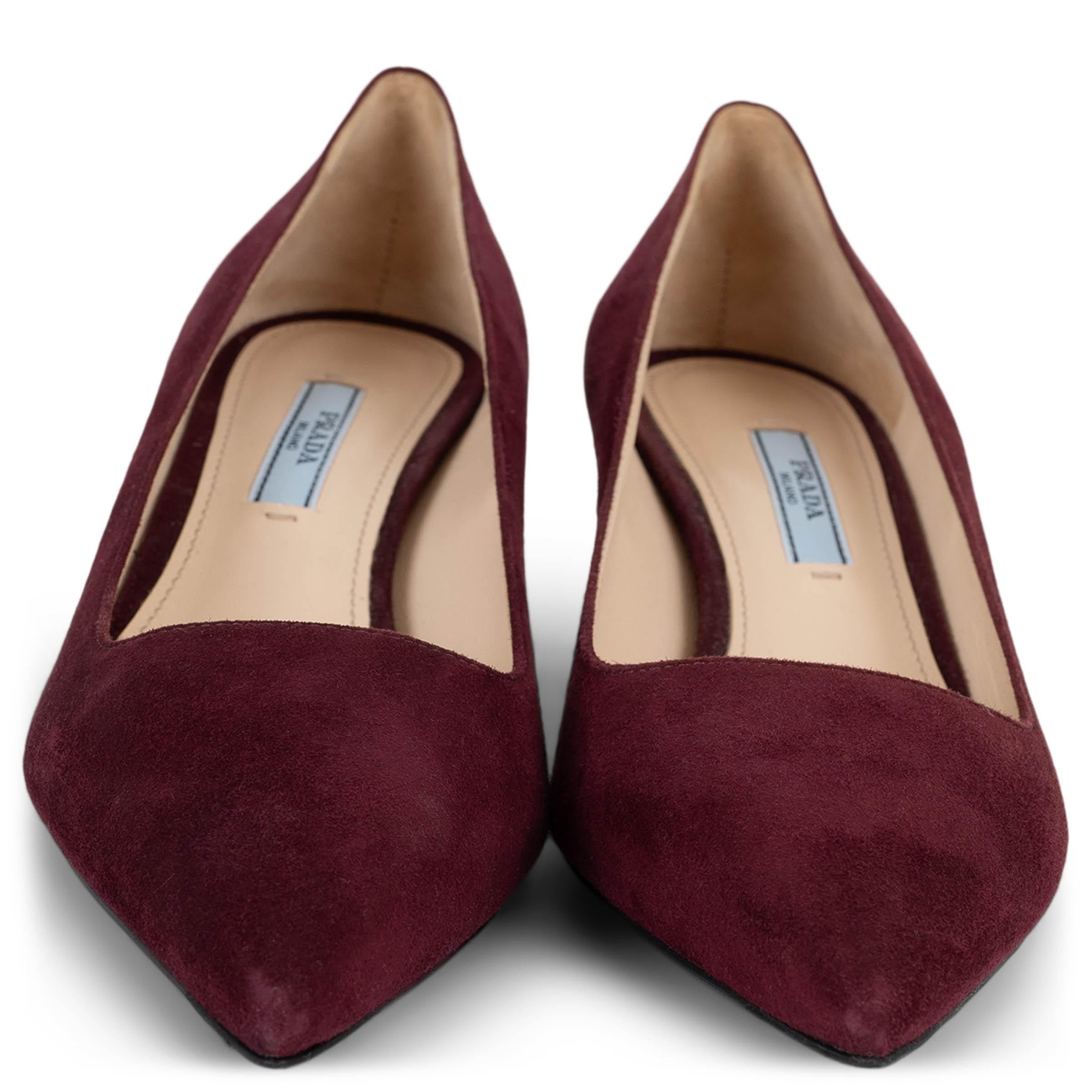 These 100% authentic Prada pointed-toe kitten-heel pumps are crafted from luxurious burgundy suede. With a sleek silhouette and comfortable low kitten heel, these pumps are the perfect blend of timeless elegance and everyday sophistication. Have