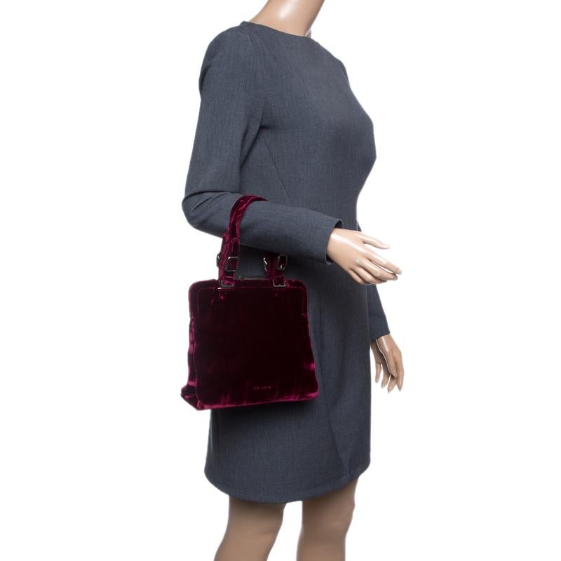 What a day for one to chance upon a bag as gorgeous as this one from Prada! It comes beautifully crafted from burgundy velvet and designed with a metal top. The bag brings two handles and a nylon-lined interior that is perfectly sized to accommodate