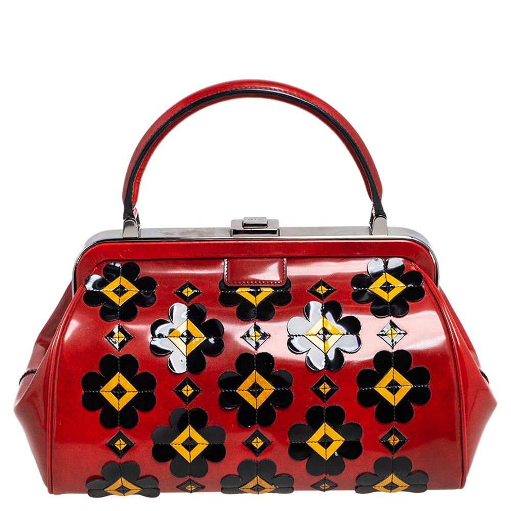 Giving handle bags an elegant update, this Doctor Frame bag by Prada will be a valuable addition to your closet. It has been crafted from patent leather and styled with floral applique details & gunmetal-toned hardware. It comes with dual top
