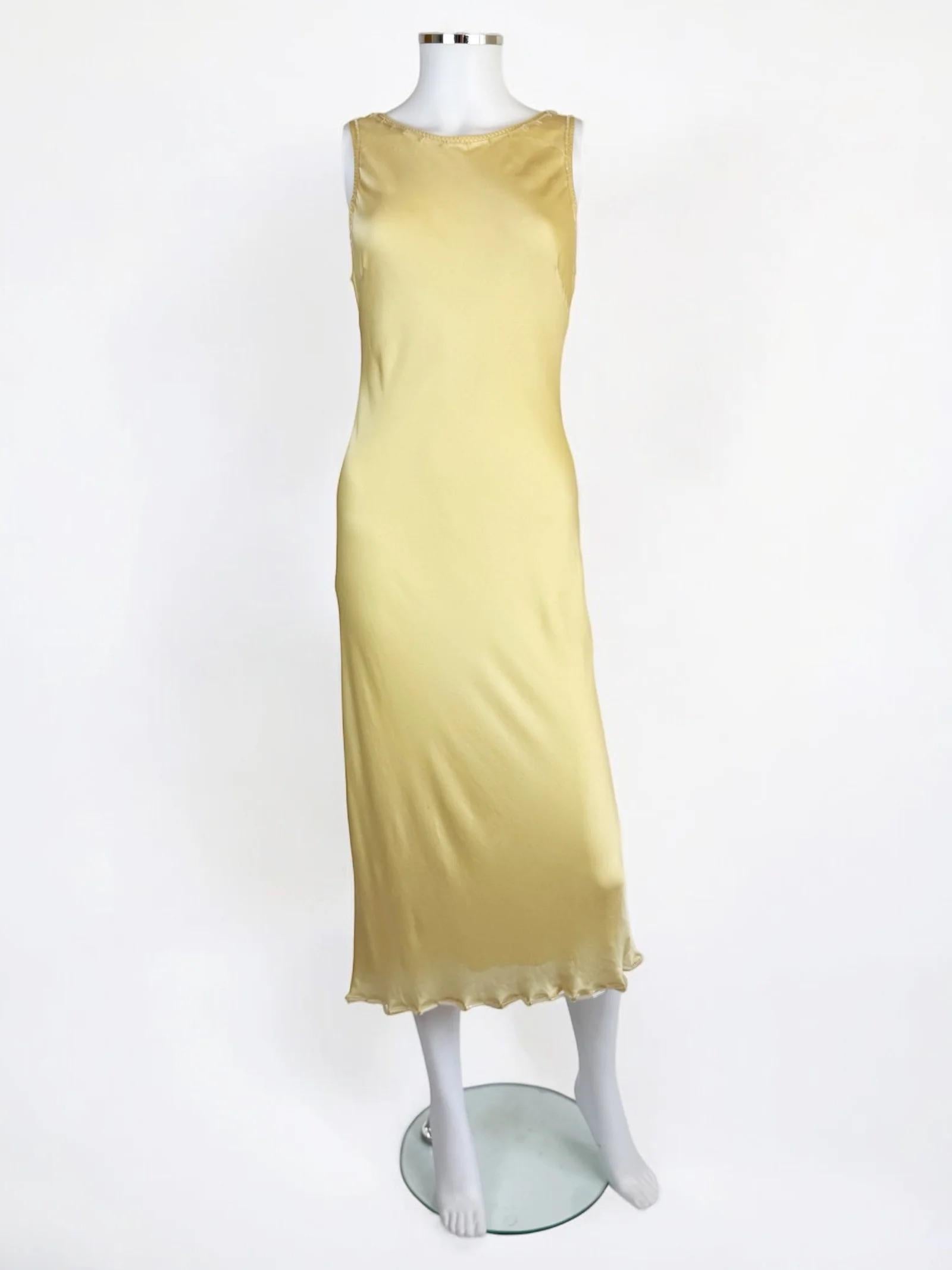 Robe en soie jaune beurre de Prada, années 1990
Longueur moyenne
Coupe de biais
L'ourlet, les bras et l'encolure sont encadrés de délicates perles cylindriques appliquées à la main dans une teinte translucide, et de coutures jaunes en zigzag.
Dos