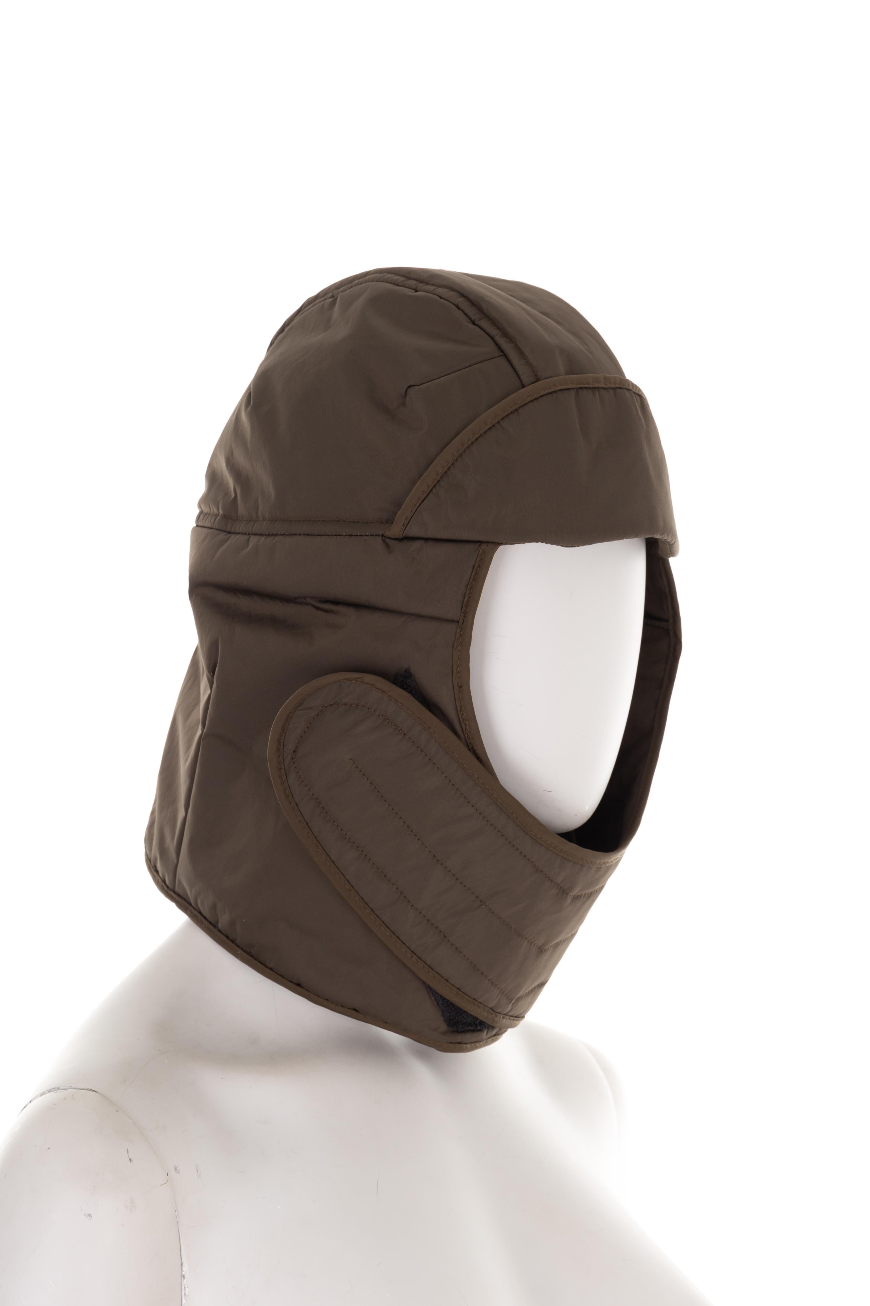 - Prada by Miuccia Prada
- Sold by Gold Palms Vintage
- Fall Winter 1999 collection
- Green nylon balaclava quilted hat
- Mini visor
- Velcro strap fastening
- Back red logo tab
- New with tags