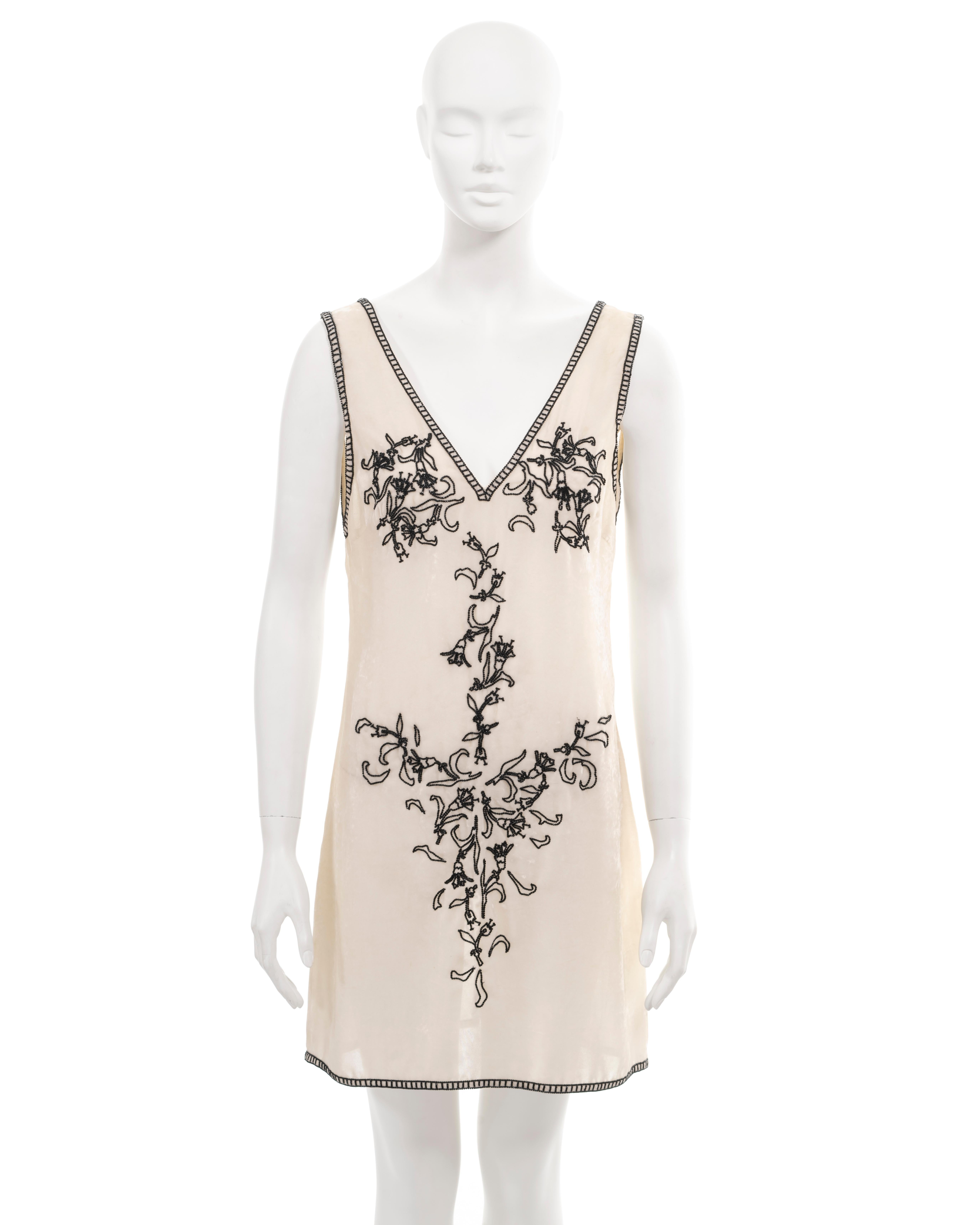 ▪ Archival Prada shift dress
▪ Creative Director: Miuccia Prada
▪ Sold by One of a Kind Archive
▪ Fall-Winter 1997
▪ Ivory crushed velvet 
▪ Black bugle-bead embellishments depict a bikini of campanula flowers and vines 
▪ Deep v-neck
▪ Low back
▪