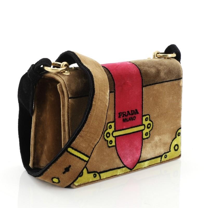 This Prada Cahier Crossbody Bag Printed Velvet Small, crafted in brown 3D-effect printed velvet, features a velvet shoulder strap and gold-tone hardware. Its magnetic snap button closures opens to a brown fabric and suede interior perfect for your