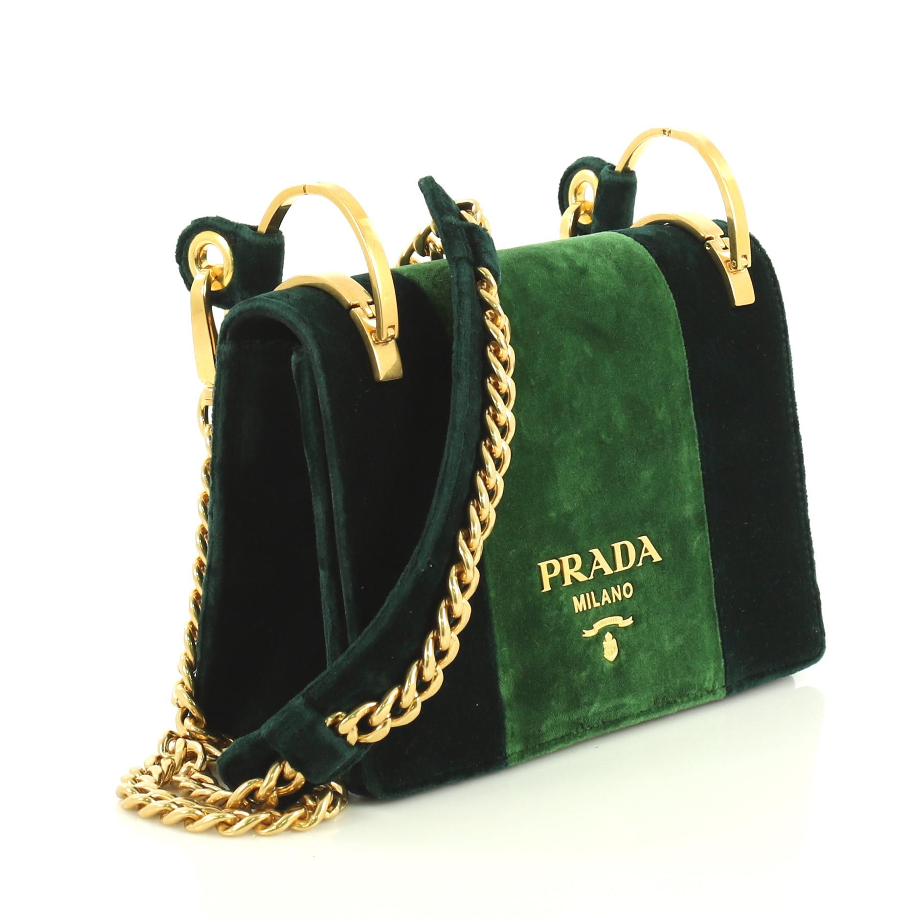 This Prada Cahier Shoulder Bag Velvet Small, crafted in green velvet, features chain link strap with shoulder pad, frontal flap and gold-tone hardware. Its magnetic snap closure opens to a black fabric and green microfiber interior with slip