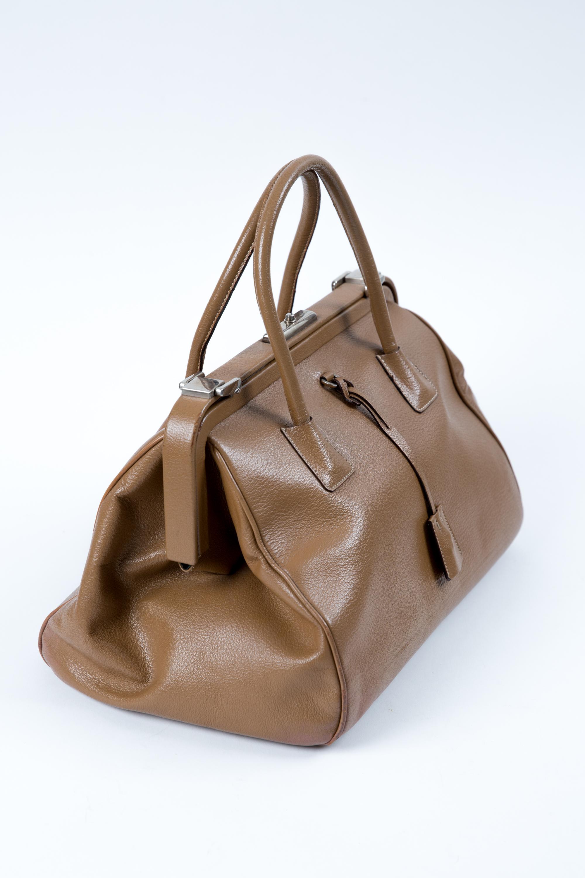 Camel Madras “Cerniera” leather doctor bag featuring silver-tone hardware, a doctor bag shape, two top leather handles, an inside logo lining, an inside zip pocket, a clochette & two  keys, a top claps top opening and an inside logo plaque. 
Circa