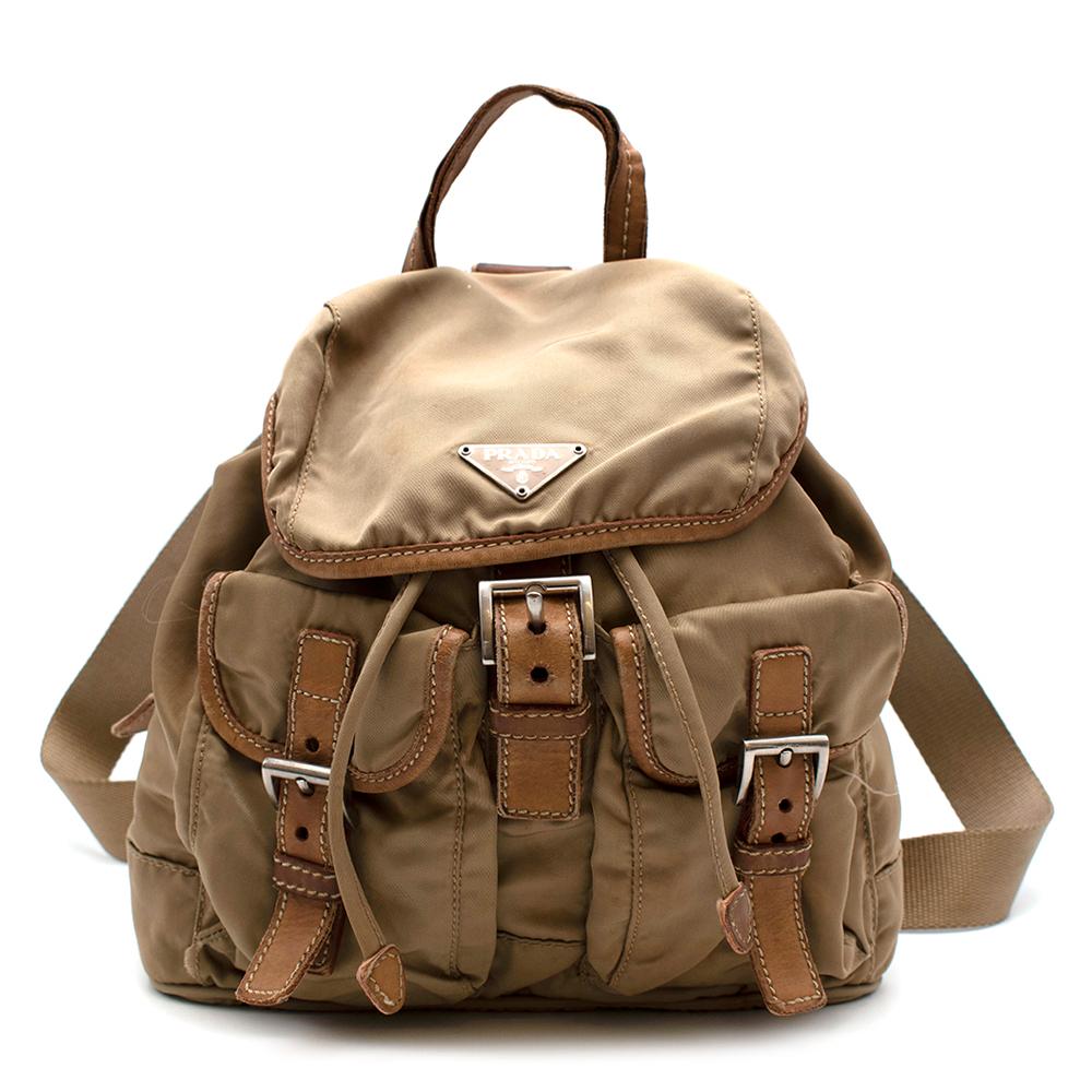 Zaino Prada Mini

- Rifiniture in pelle intorno ai bordi con firma in pelle saffiano 
- Maniglia superiore
- Hardware d'argento
- Due mini tasche con fibbie sulla parte anteriore della borsa
- Chiusura magnetica con cinturino a fibbia sulla parte