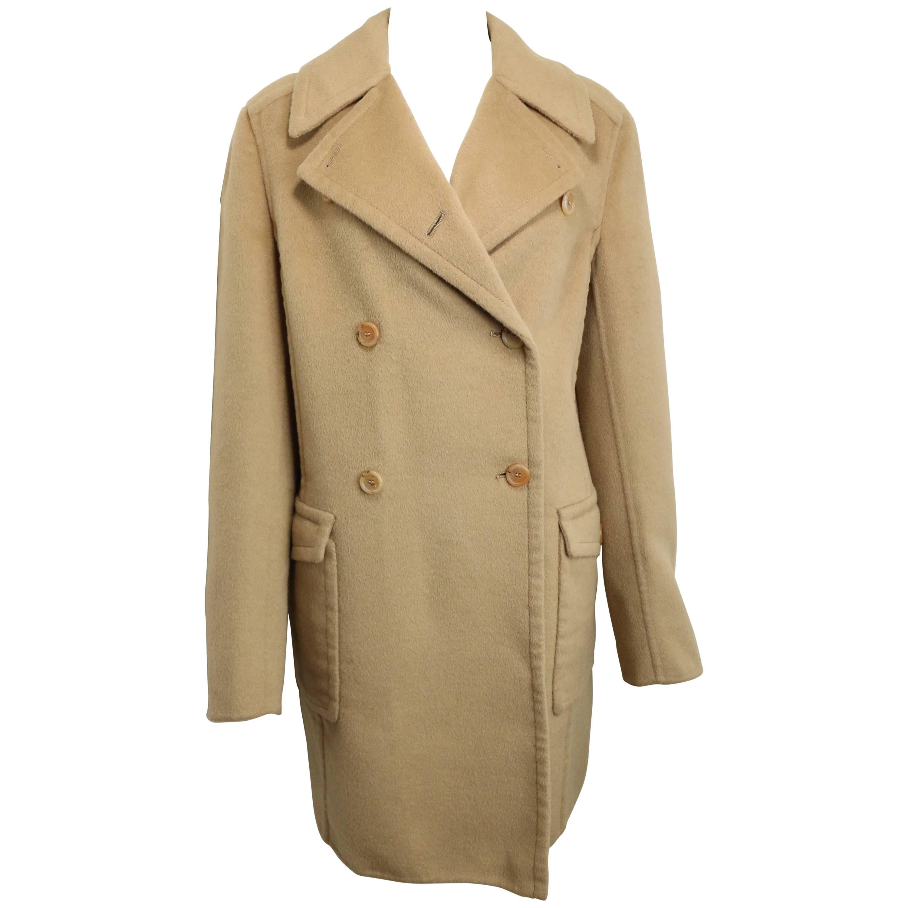 - Cappotto doppiopetto in lana di capra cammello vintage anni '90 di Prada. 

- Presenta otto bottoni frontali, due tasche con patta e bottoni e un cinturino posteriore in vita. 

- 52% lana, 48% pelo di capra d'angora. 

- Taglia 44 Italia. 

-