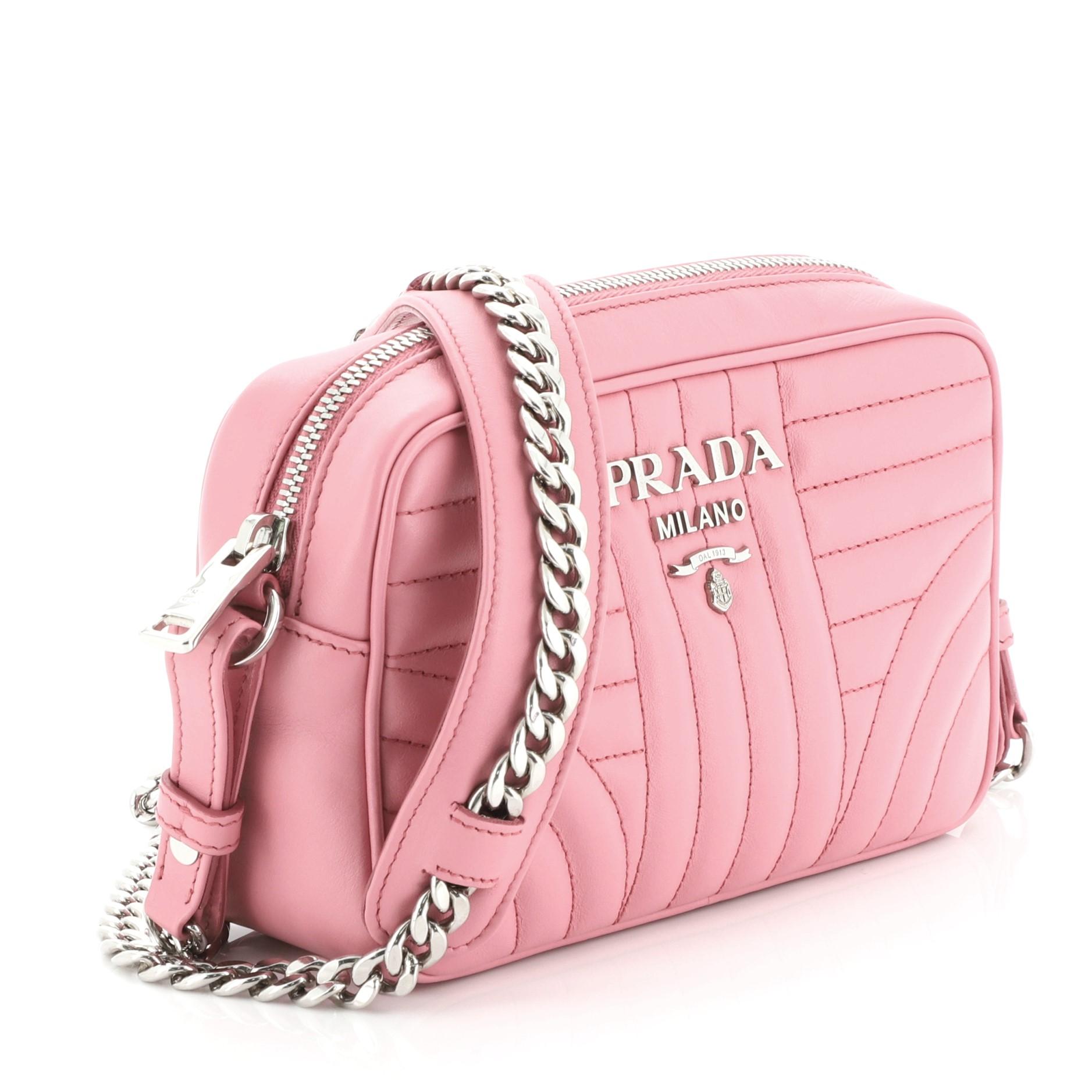 This Prada Camera Bag Diagramme Quilted Leather Mini, crafted from pink diagramme quilted leather, features a chain link strap and silver-tone hardware. Its zip closure opens to a pink fabric interior with slip pocket. 

Estimated Retail Price: