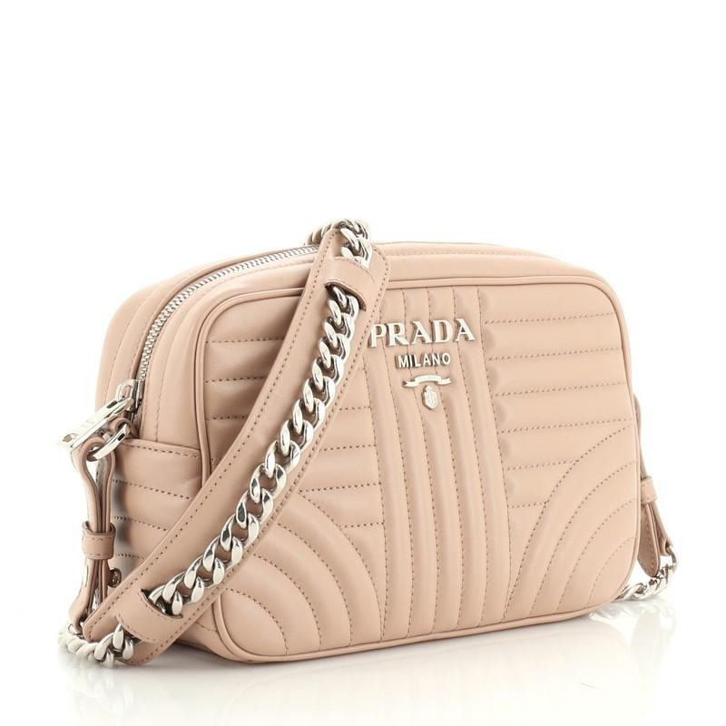 This Prada Camera Bag Diagramme Quilted Leather Small, crafted from pink quilted leather, features a chain link strap and silver-tone hardware. Its zip closure opens to a neutral fabric interior with slip pocket. 

Estimated Retail Price: