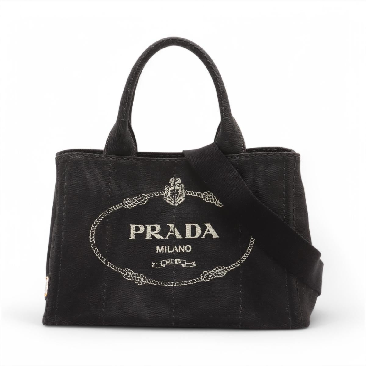 *will ship about 4/1

The Prada Canapa Canvas Two-Way Handbag in Black is a stylish and versatile piece that blends casual elegance with practicality. Crafted from durable black canvas, it features the iconic Prada Milano logo printed on the front,