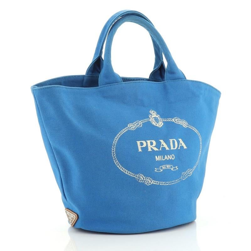 This Prada Canapa Convertible Shopping Tote Canvas Medium, crafted in blue canvas, features dual top handles and silver-tone hardware. It opens to a blue canvas interior with side zip pocket. 

Estimated Retail Price: $1,150
Condition: Good. Small