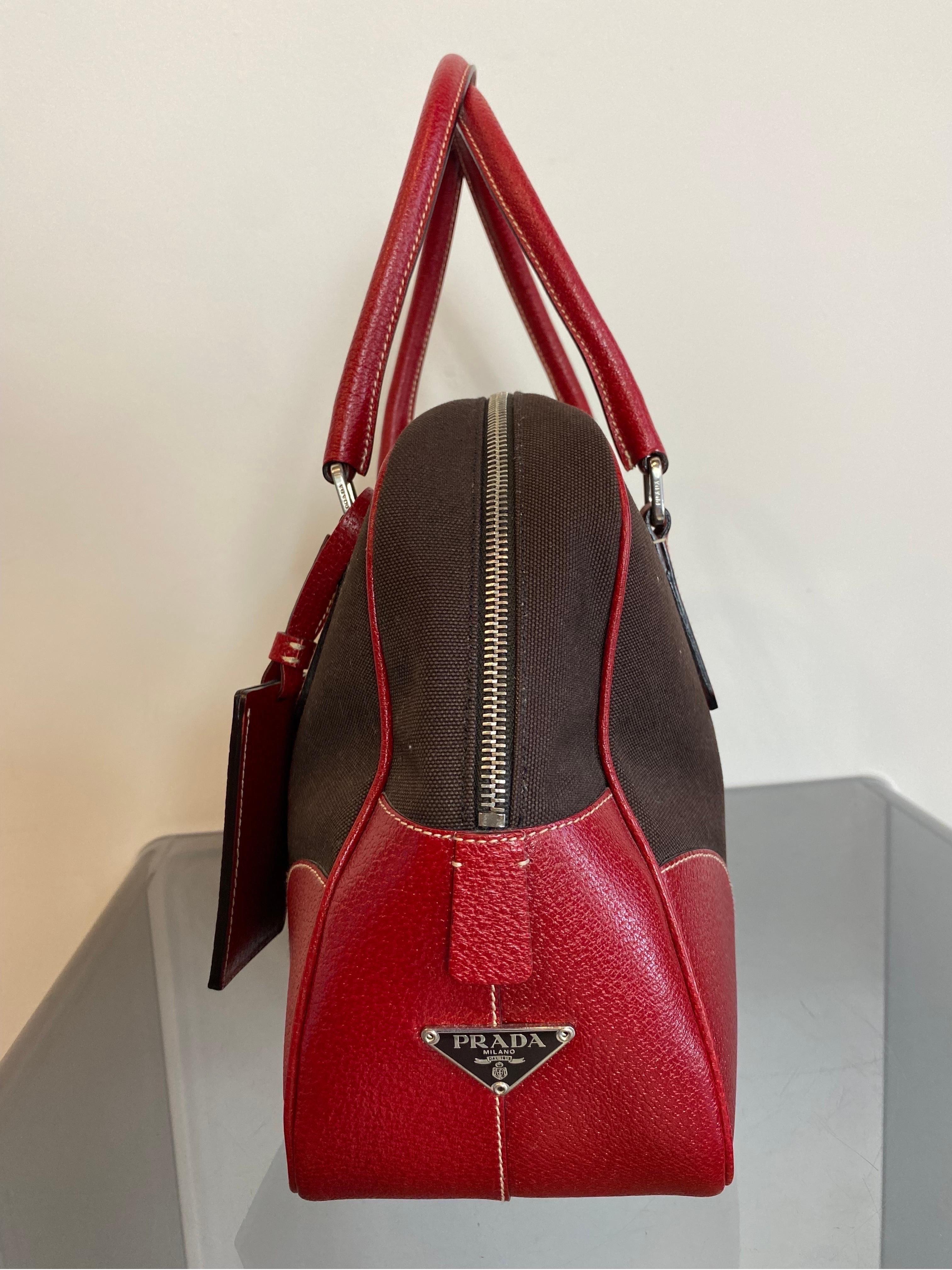 Prada hemp top case
Made of hemp and straps. Dark brown and red color.
Canvas body with leather trim. Rolled leather handles, top zip closure and internal zip pocket. 
Comes with authenticity card. 
Possibility of safety closure via padlock. 
Keys