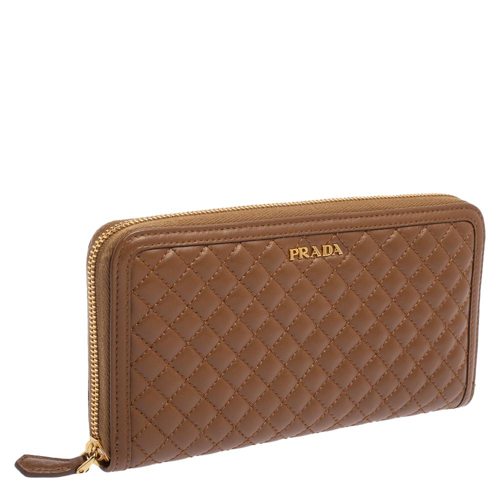 Luxe and classy, this zip-around wallet is from Prada. It has been crafted from soft quilted leather and equipped with a zipper leading to multiple slots and compartments for you to neatly carry your essentials. A gold-tone brand detail is placed on