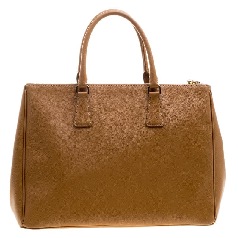 This elegant tote from Prada is crafted from Saffiano lux leather and is perfect for daily use. The bag features double handles, leather key ring, and protective metal feet. The nylon lined spacious interior will hold all your belongings and houses