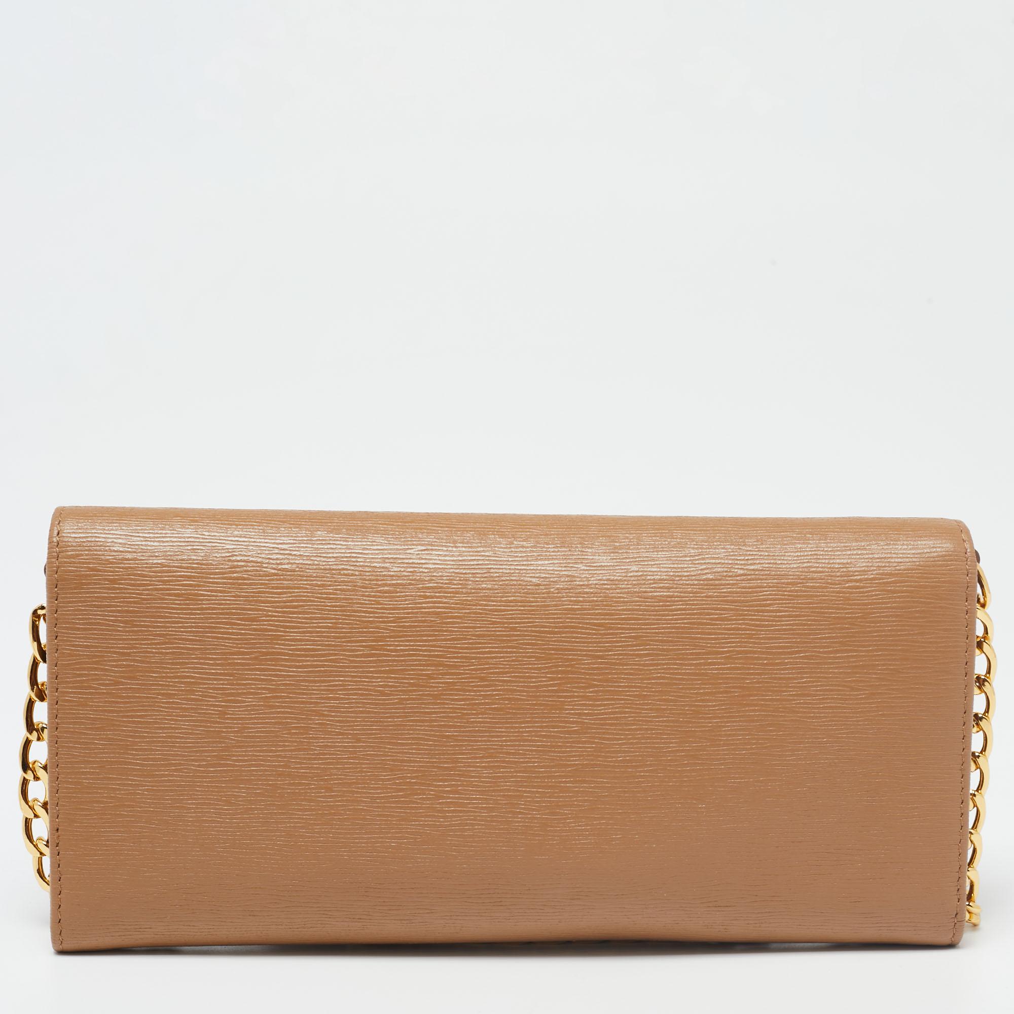 Now here's a creation that is both stylish and functional! The house of Prada brings us this wallet on chain that will make you look glamorous! It is made from caramel-hued leather and features a gold-tone logo accent on the front. It is completed