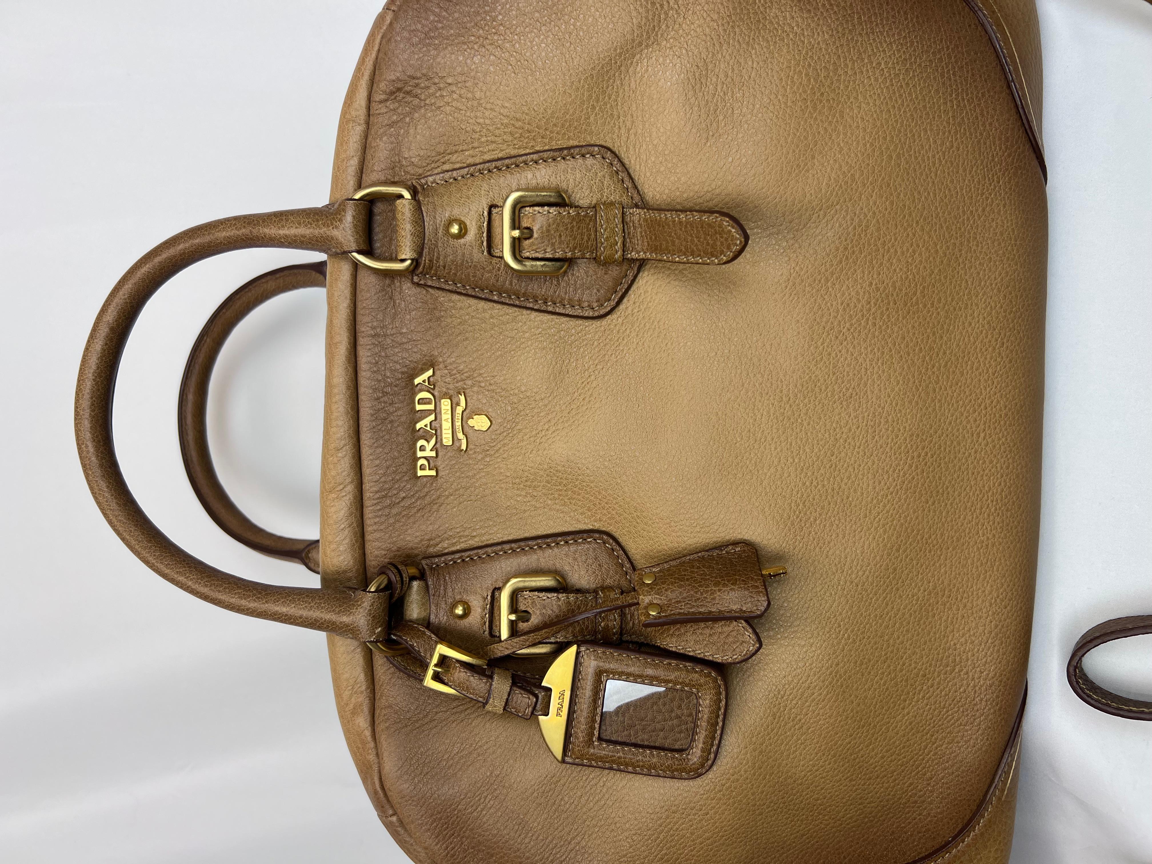 Crafted from luxurious light brown calfskin leather, the Prada Cervo Antik Bowler bag is a sophisticated accessory that blends timeless style with everyday functionality. Its rich, textured leather features a lightly distressed finish for an