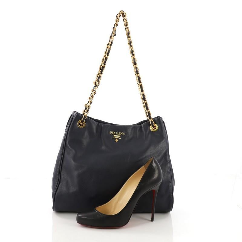 This Prada Chain Tote Soft Calfskin Large, crafted in navy soft calfskin leather, features dual woven-in leather chain straps, raised Prada logo, and gold-tone hardware. It opens to a navy fabric interior with side zip and slip pockets. **Note: Shoe