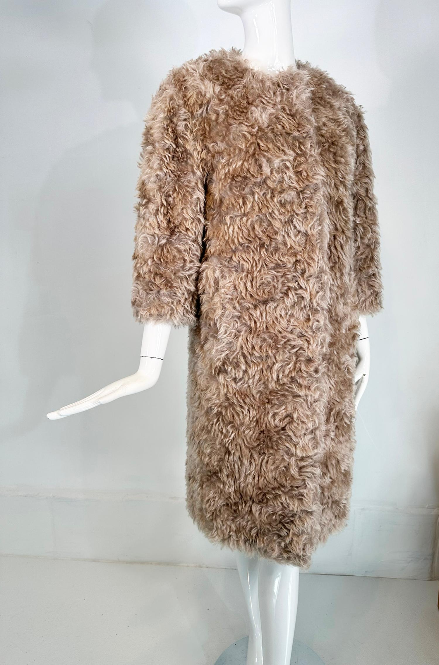 Prada champagne mohair/cotton blend, jewel neck, big snaps closure, faux fur teddy bear coat, marked size 38.
Fun fur in a fluffy curly mohair/cotton blend. Jewel neck (round, no collar), closes at the front with giant snaps. There are hip front