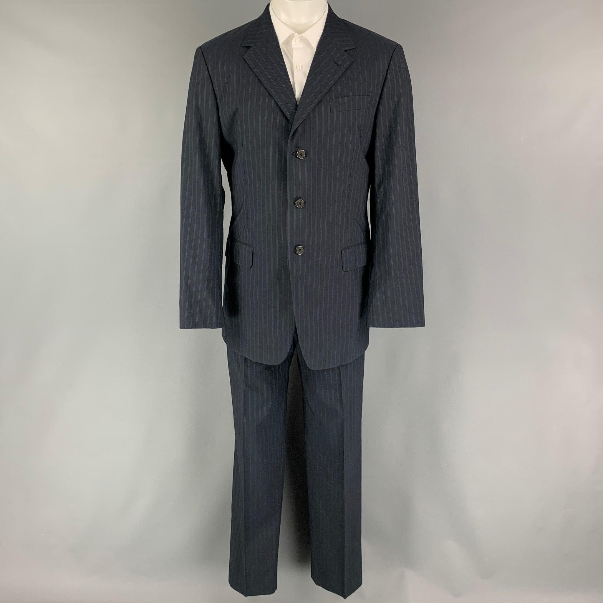 PRADA suit comes in a navy stripped cotton woven material with a full liner and includes a single breasted, three button sport coat with a notch lapel and matching flat front trousers. Made in Italy.Excellent Pre-Owned Condition. 

Marked:   50