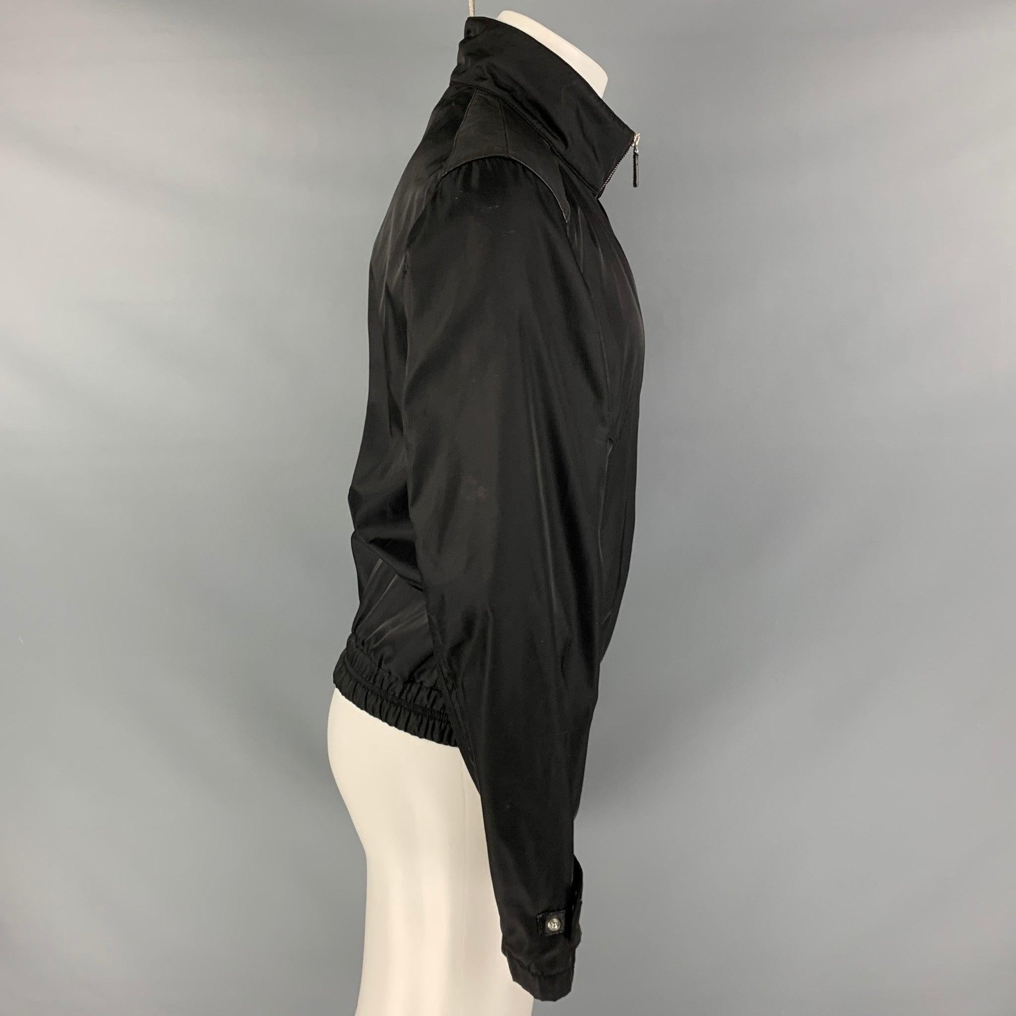 PRADA Sport jacket comes in a black nylon material featuring a bomber style, zipper pockets, leather detail on shoulder, elastic bottom hem, and a full zip up closure. Excellent Pre-Owned Condition. 

Marked:   40 

Measurements: 
 
Shoulder: 17.5