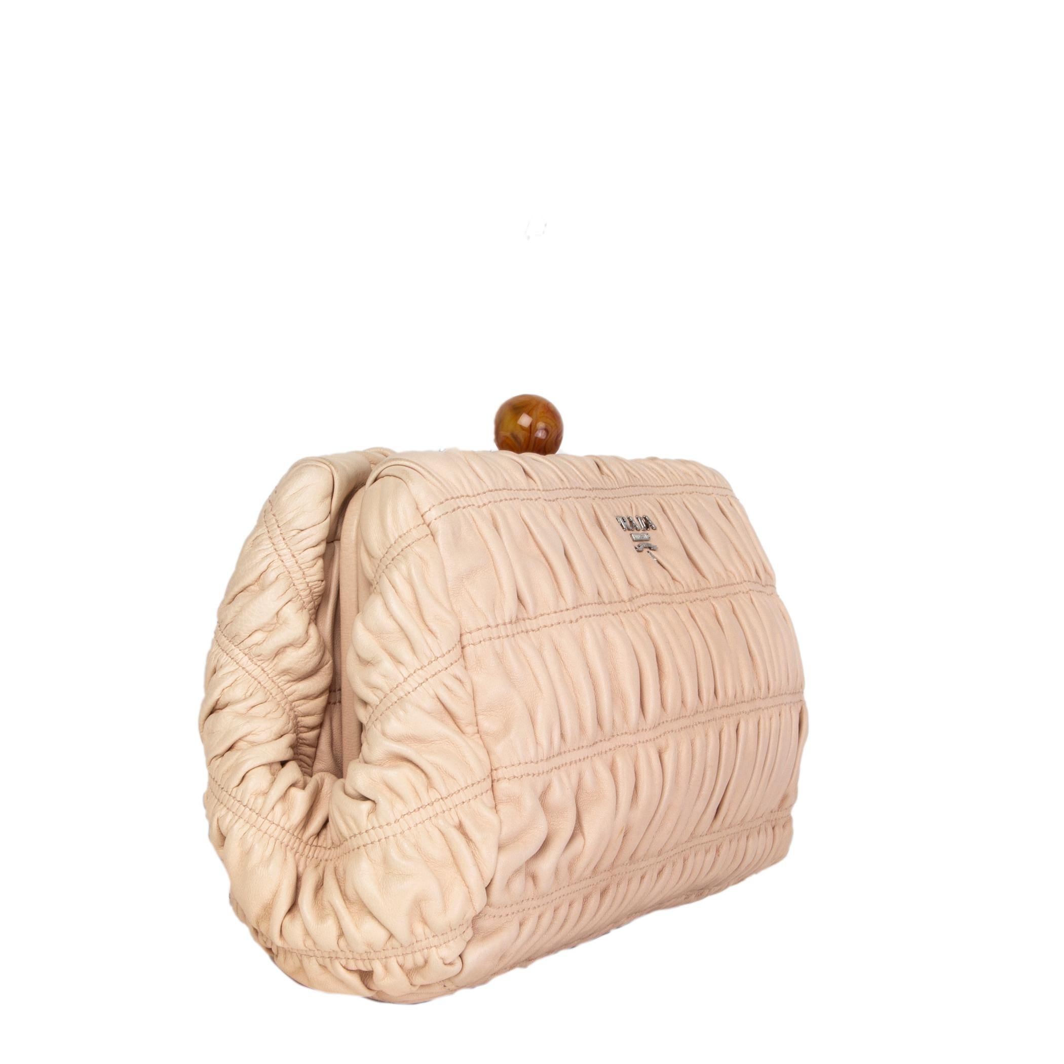 Prada frame clutch in Cipria (dust rose) Gaufre ruched leather. Cognac and caramel colored resin marble ball closure. Lined in dusty rose lambskin leather with an open pocket against the front and an open and zipper pocket against the back. Has been
