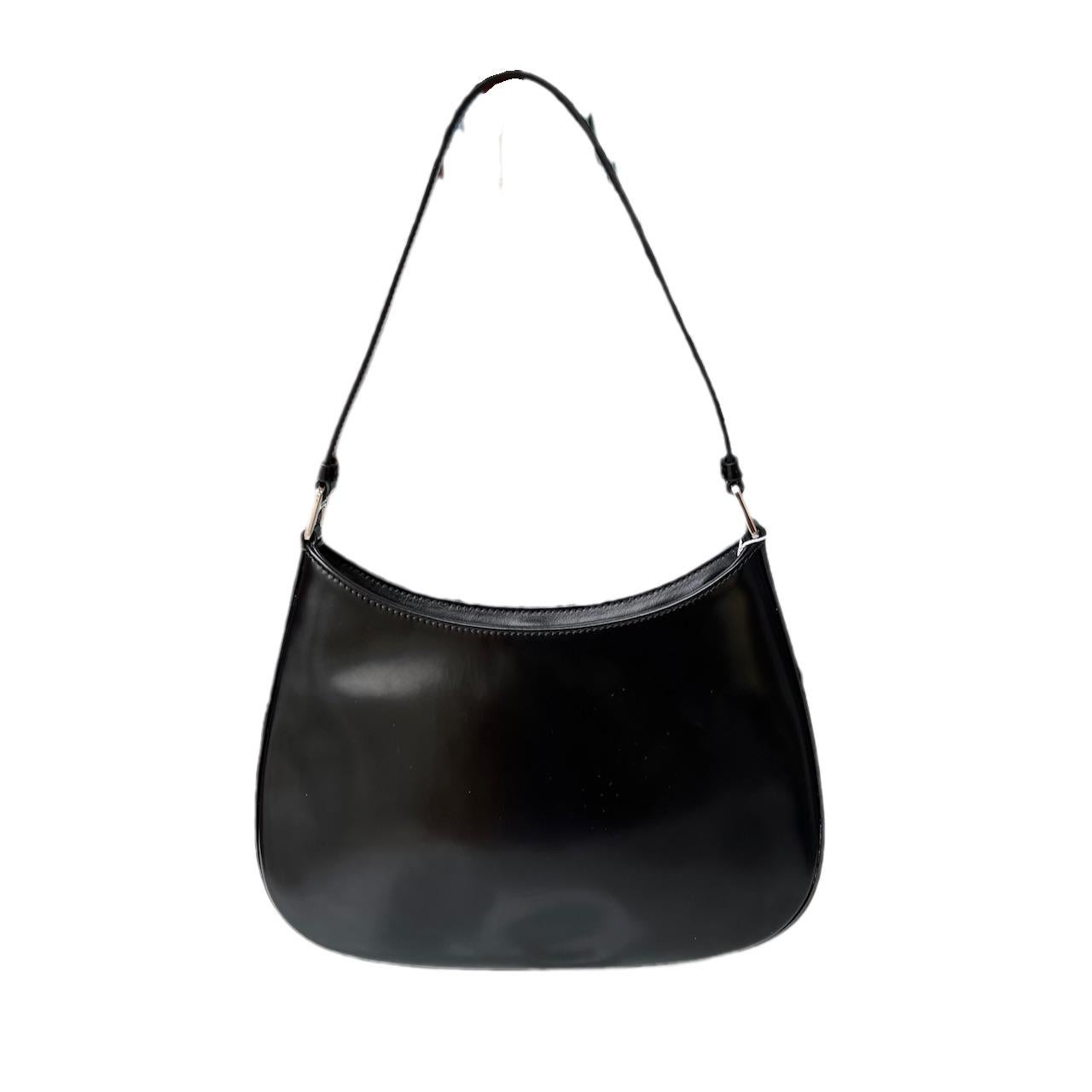 The Prada Cleo Black leather shoulder bag is a timeless classic. It is crafted from a smooth black leather with a mirror glaze shine. Combining luxury with simplicity, the Prada Cleo is the epitome of class and sophistication.

Minor indents on the