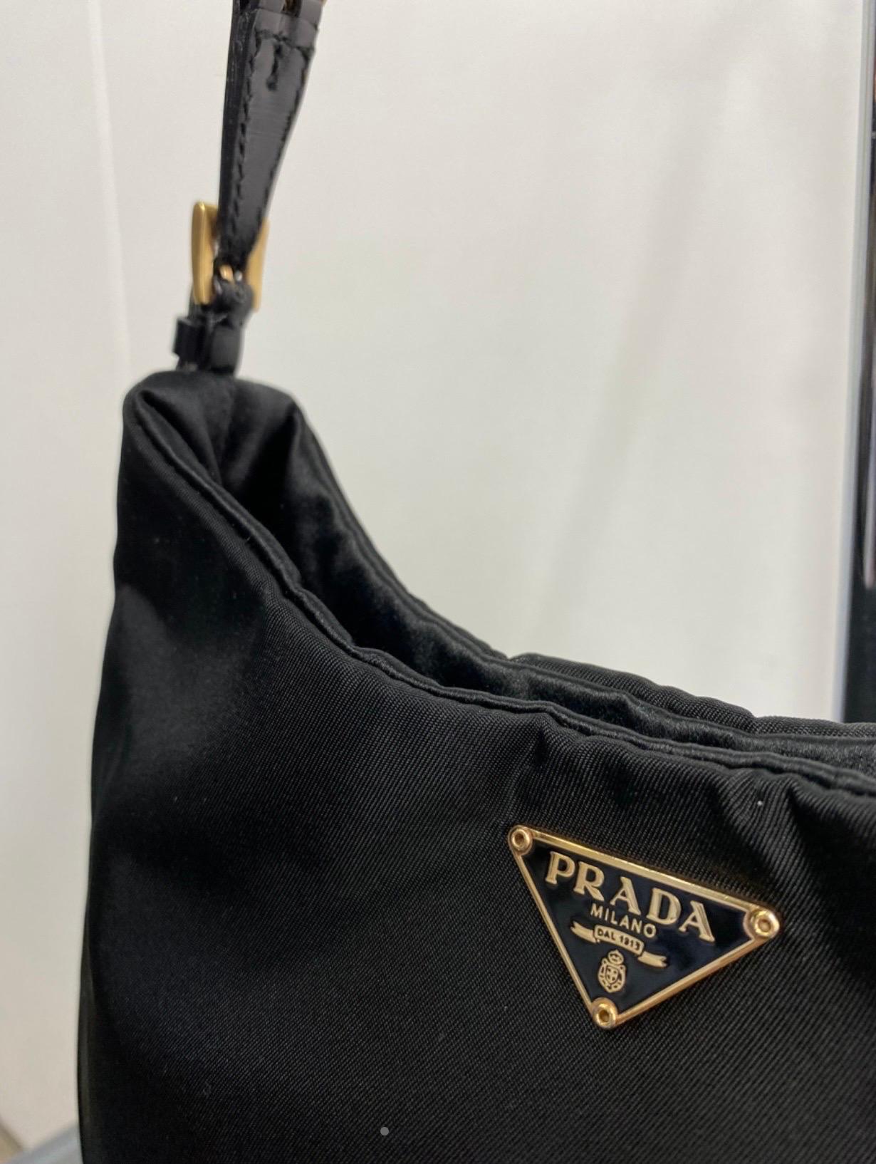 Prada Cleo vintage bag.
Both hand or shoulder bag.
In black iconic nylon. Golden chain shoulder strap. 
Measurements: 27X18X3 cm.
Excellent condition. It comes with original dust bag.