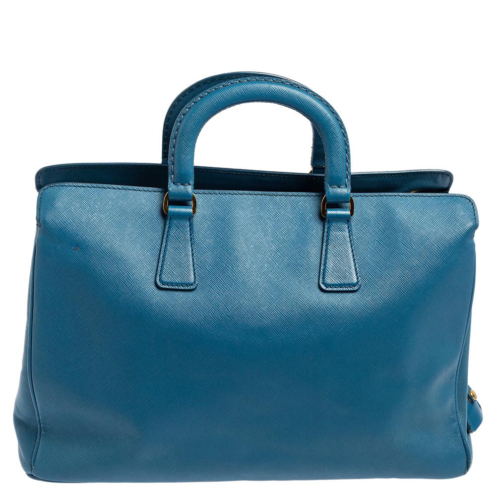 The House of Prada, with its impeccable skill and craftsmanship, has designed this Middle Zip tote. This tote features an exterior made using cobalt Saffiano Lux leather with a gold-toned logo embellishing the front. Made to offer luxurious style